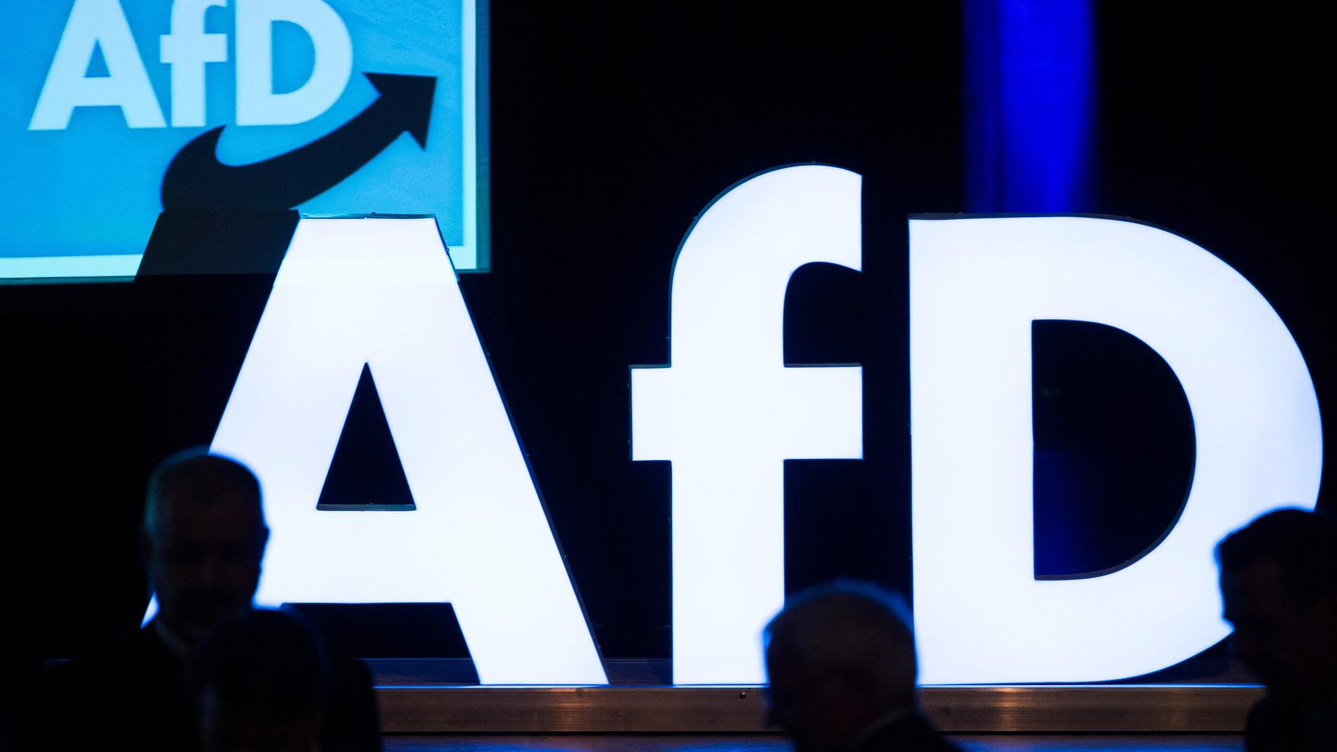 Das Foto zeigt ein Schild von der Partei AfD auf einer Bühne