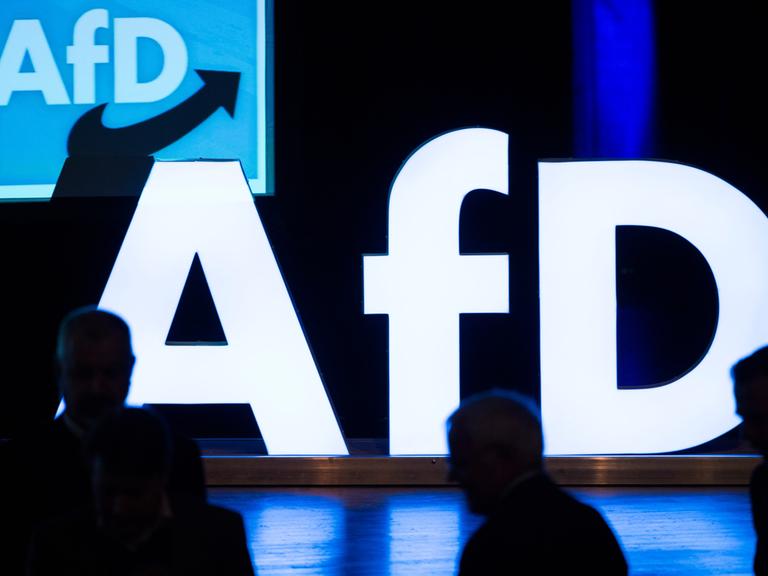 Das Foto zeigt ein Schild von der Partei AfD auf einer Bühne