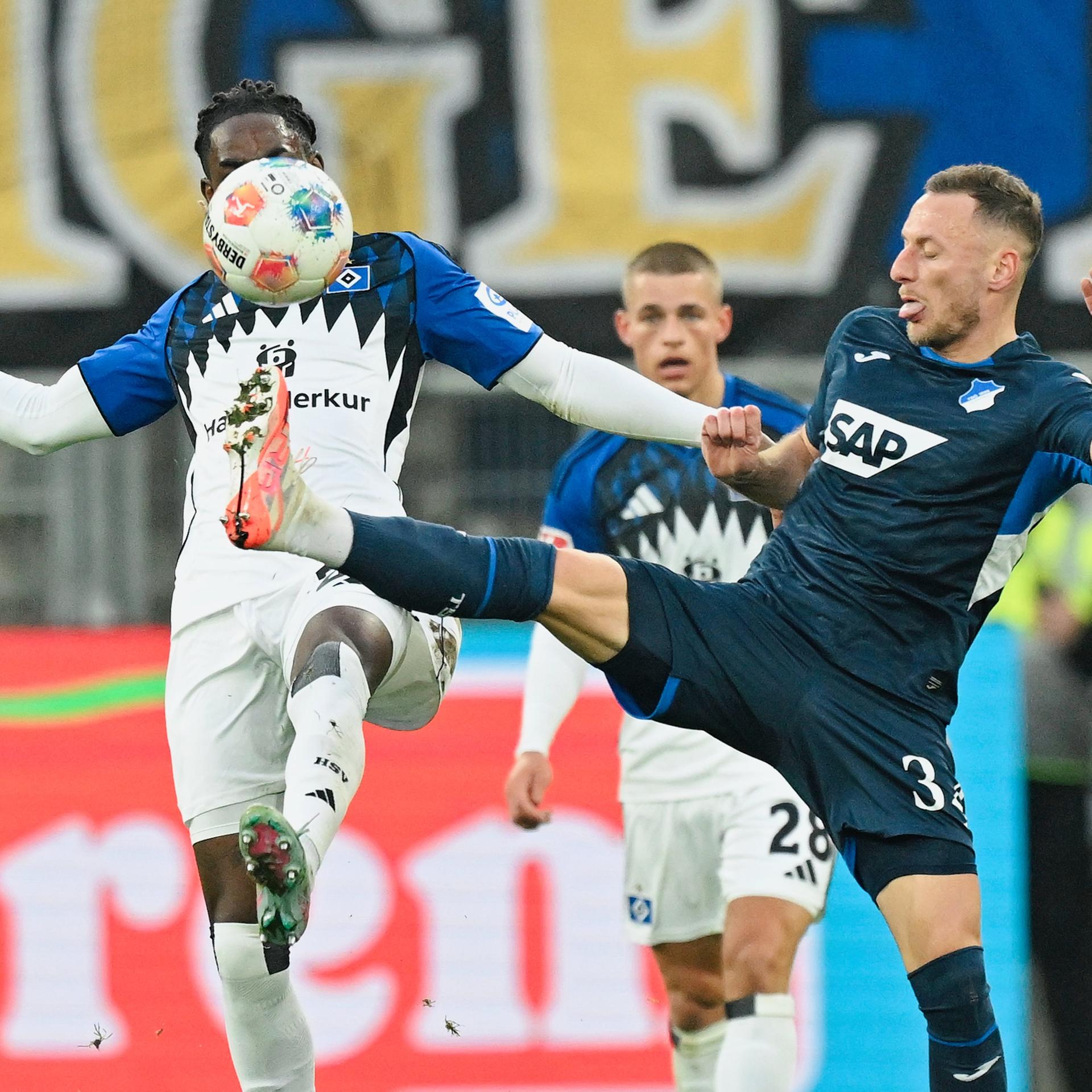 Zwei Fußballspieler kämpfen um den Ball. 