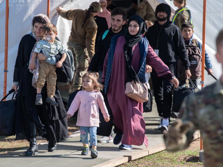 Kinder und Familien aus Afghanistan tragen vor ihrem Abflug in die USA ihr Gepäck zu einer Sammelstelle. 