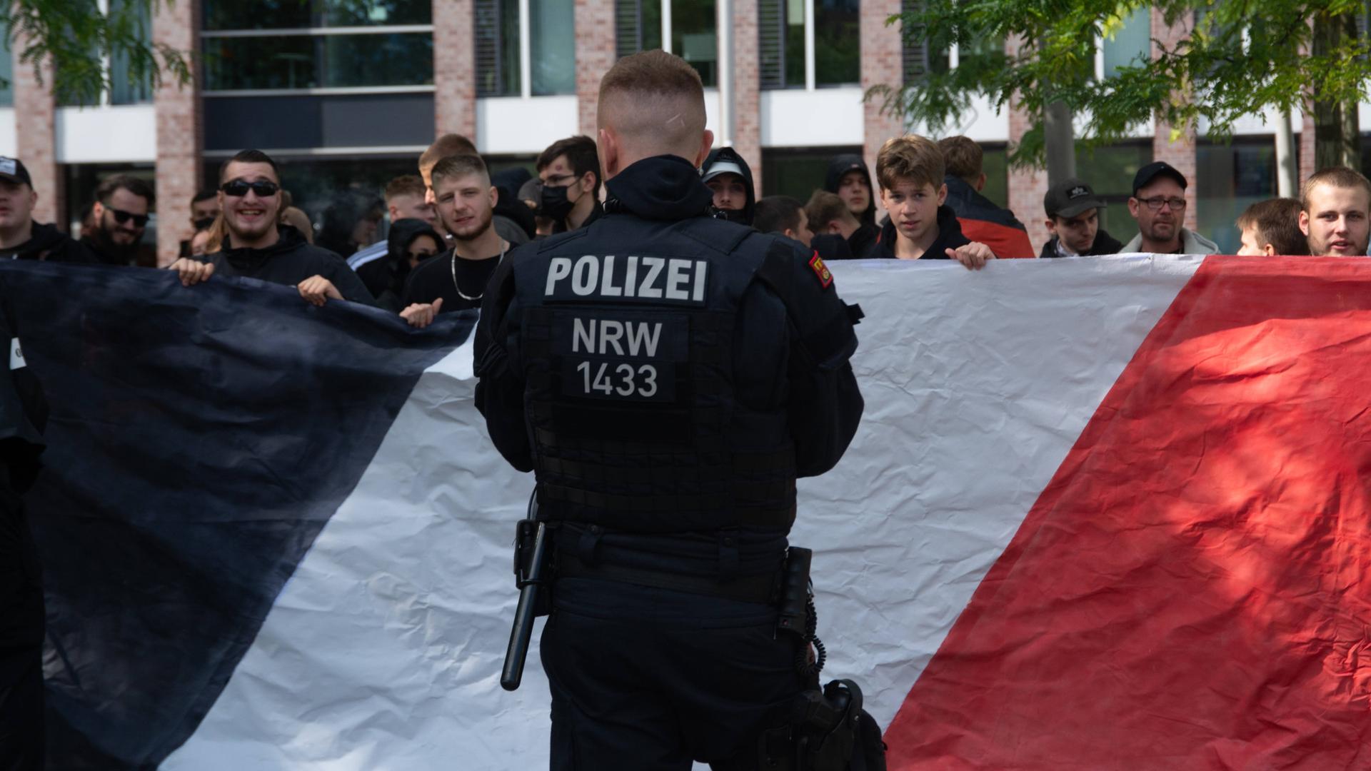 Polizisten stehen einer Gruppe von Rechten Demonstranten gegenüber