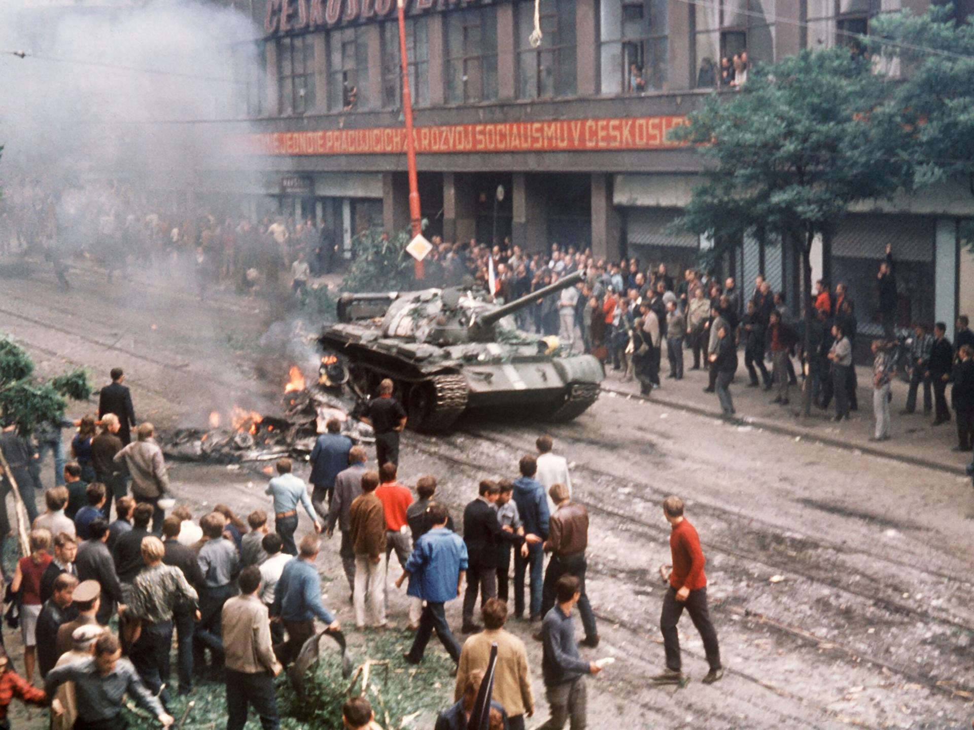 Eine Menschenmenge umringt am ersten Tag der Besetzung in der Prager Innenstadt einen russischen Panzer, der neben einem ausgebrannten Fahrzeug zum Stehen gekommen ist. Eine Menschenmenge umringt am ersten Tag der Besetzung in der Prager Innenstadt einen russischen Panzer, der neben einem ausgebrannten Fahrzeug zum Stehen gekommen ist.