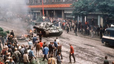 Eine Menschenmenge umringt am ersten Tag der Besetzung in der Prager Innenstadt einen russischen Panzer, der neben einem ausgebrannten Fahrzeug zum Stehen gekommen ist. Eine Menschenmenge umringt am ersten Tag der Besetzung in der Prager Innenstadt einen russischen Panzer, der neben einem ausgebrannten Fahrzeug zum Stehen gekommen ist.