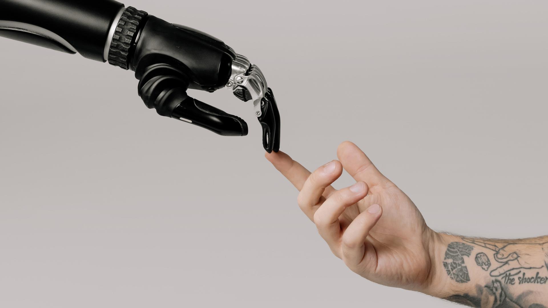 Eine Hand eines Roboters berührt eine menschliche Hand