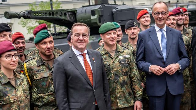 Bundeskanzler Merz (CDU, r) steht mit Verteidigungsminister Pistorius (SPD, M) bei Soldaten der Panzerbrigade 45 der Bundeswehr. Sie ist dauerhaft in Litauen stationiert und soll die Ostflanke der NATO unterstützen