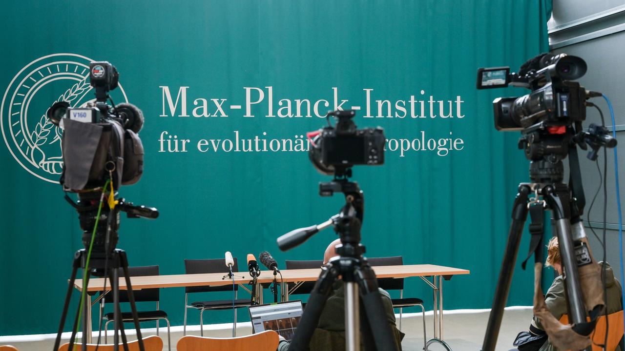 Schriftzug des Max-Planck-Instituts für evolutionäre Anthropologie Leipzig auf einer Rückwand auf einer Pressekonferenz.
      