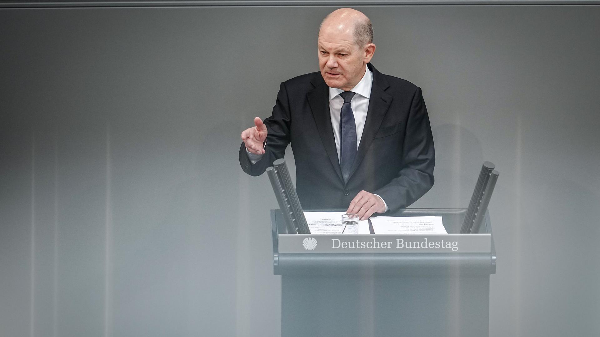 Bundeskanzler Scholz spricht am Rednerpult im Plenarsaal des Bundestags.