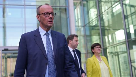 Der CDU-Vorsitzende Friedrich Merz nach der Pressekonferenz zu den Sondierungsgesprächen von Union und SPD. Im Hintergrund: Die SPD-Vorsitzenden Lars Klingbeil und Saskia Esken.