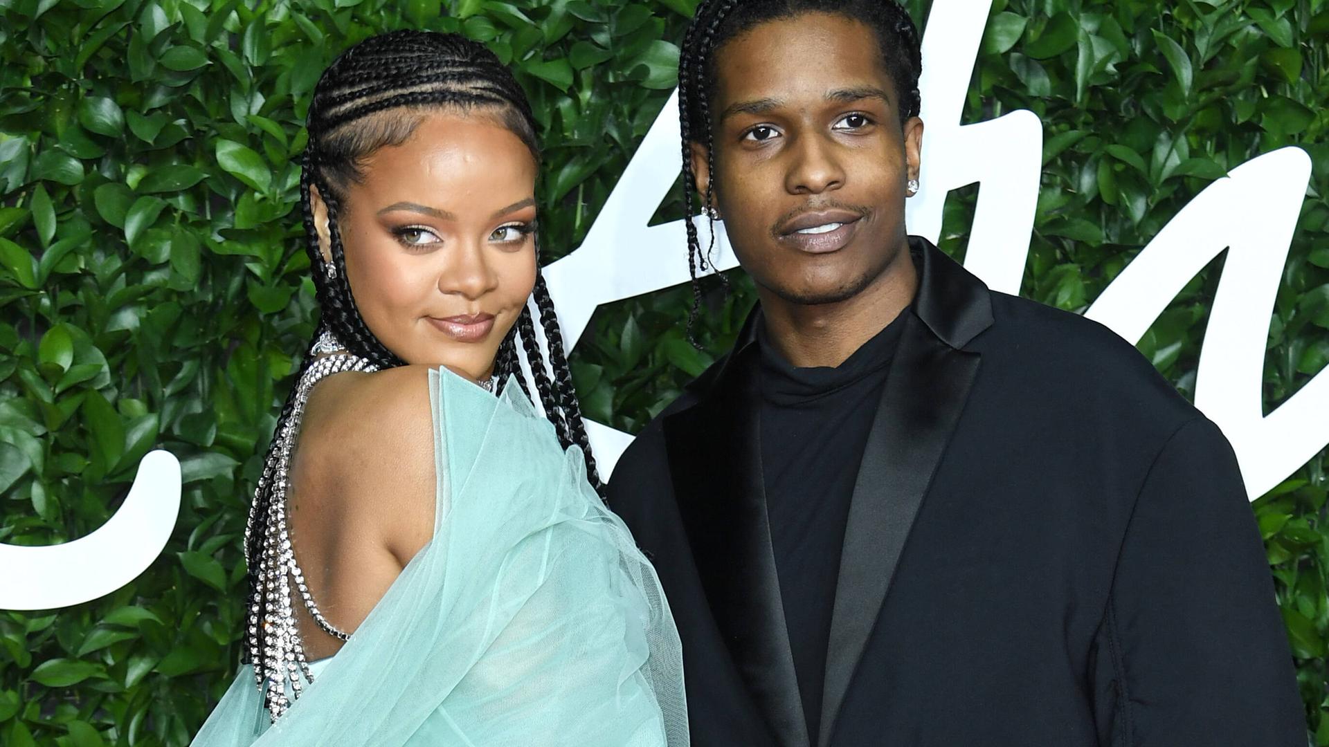 Rihanna im türkisen Kleid umarmt ihren Partner A$AP Rocky, der einen schwarzen Anzug trägt. Rihanna im türkisen Kleid umarmt ihren Partner A$AP Rocky, der einen schwarzen Anzug trägt.