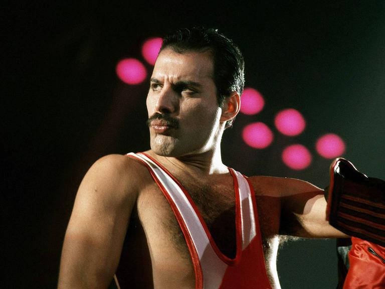 Freddie Mercury steht auf der Bühne. Freddie Mercury steht auf der Bühne.