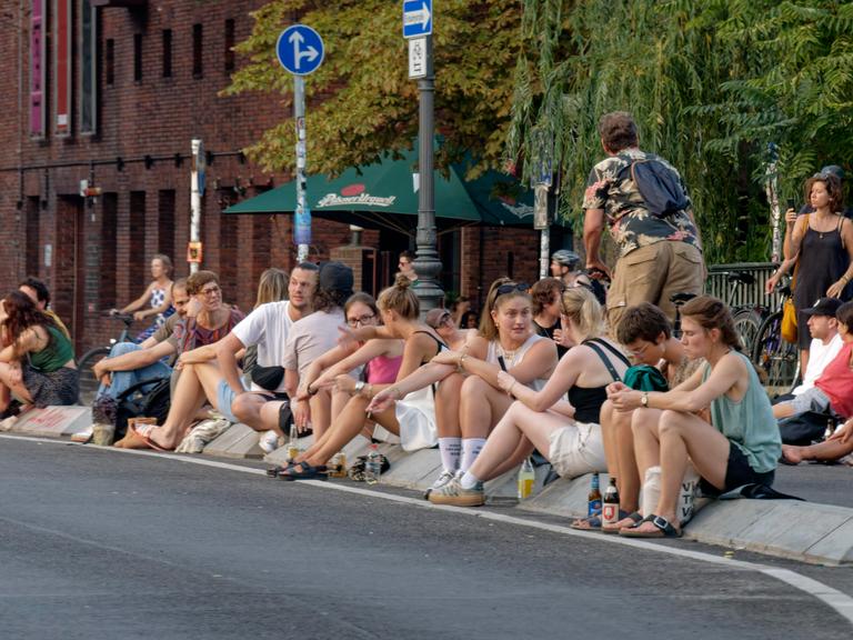 Viele junge Menschen sitzen auf dem Straßenpflaster der Berliner Hobrechtbrücke, Hot Spot, Sommer in Berlin, zwischen Berlin-Neukoelln und Berlin-Kreuzberg. Viele junge Menschen sitzen auf dem Straßenpflaster der Berliner Hobrechtbrücke, Hot Spot, Sommer in Berlin, zwischen Berlin-Neukoelln und Berlin-Kreuzberg.