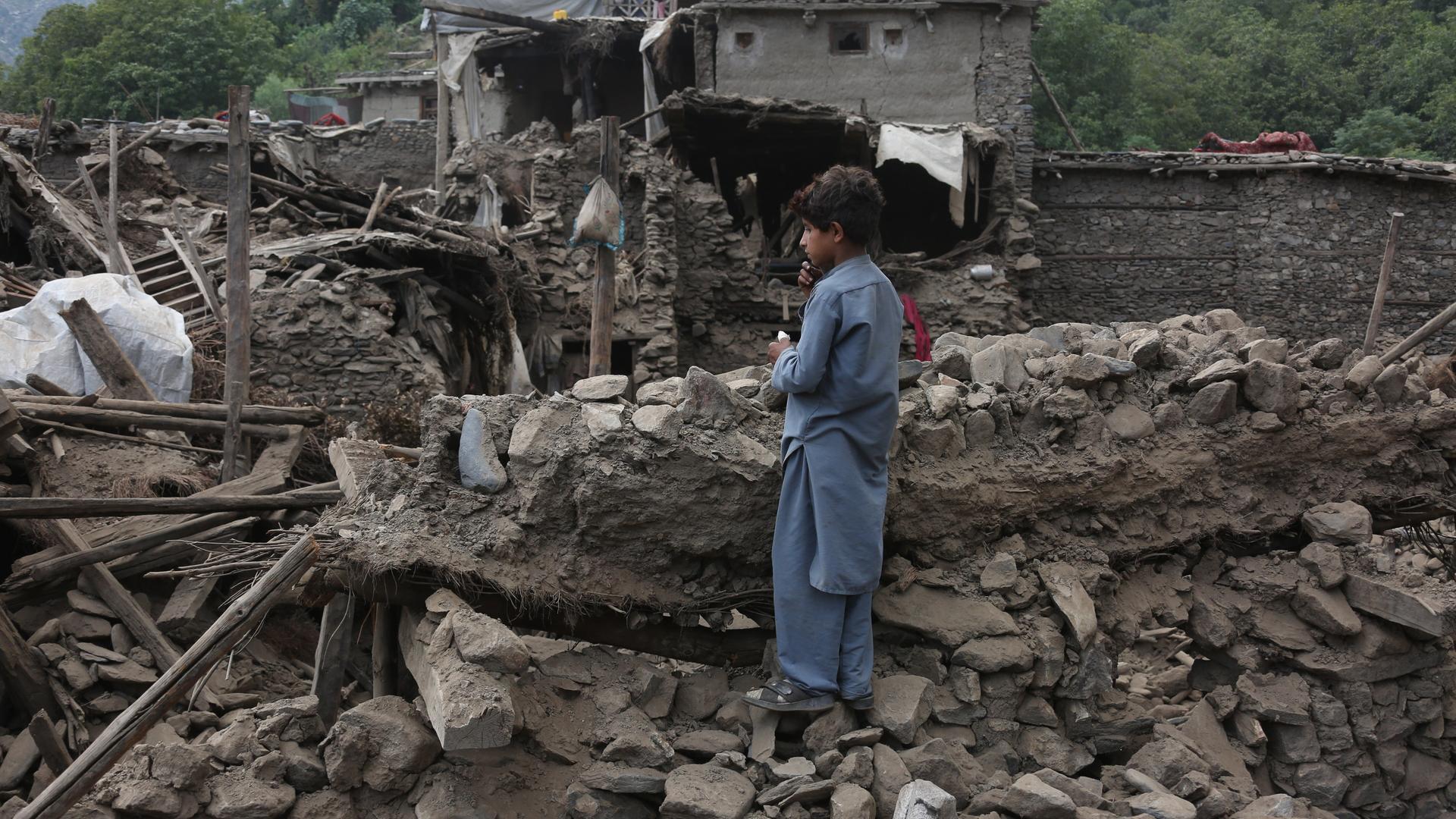 Ein Junge steht neben Ruinen von Wohnhäusern nach dem Erdbeben in der Kunar-Provinz in Afghanistan. Ein Junge steht neben Ruinen von Wohnhäusern nach dem Erdbeben in der Kunar-Provinz in Afghanistan.