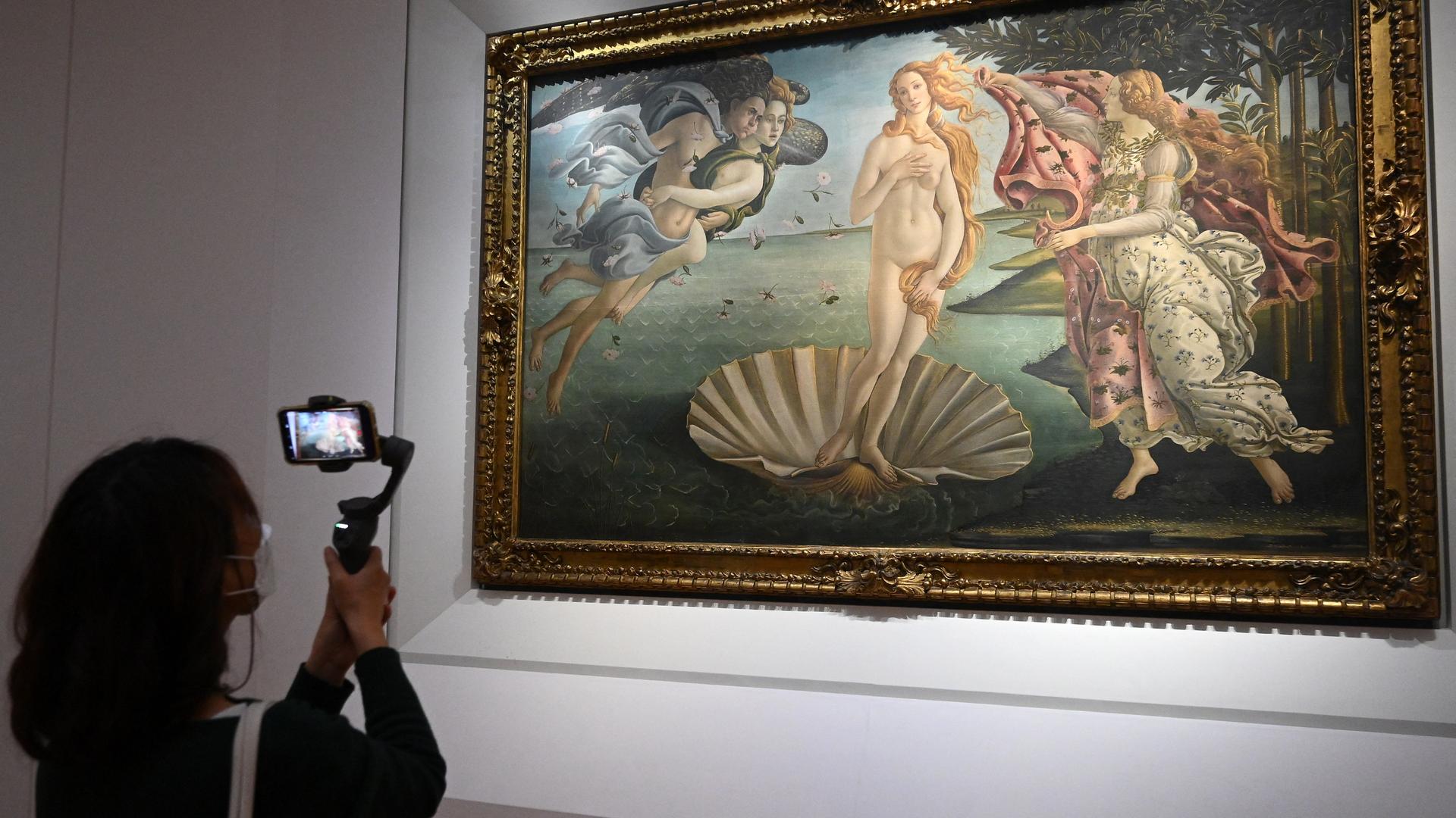 Ein Museumsbesucher fotografiert das Gemälde "Geburt der Venus".