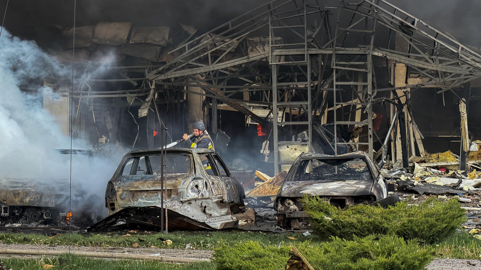 Ein Mann versucht nach einem russischen Angriff auf die ukrainische Stadt Saproischja ein Feuer zu löschen.