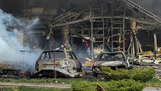 Ein Mann versucht nach einem russischen Angriff auf die ukrainische Stadt Saporischschja ein Feuer zu löschen.