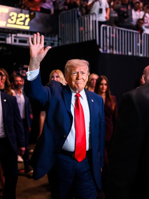 US-Präsident Donald Trump zieht ins Kaseya Center in Miami, Florida zu einem Kampfsportevent der UFC an der Seite von UFC-Chef Dana White ein. Trump trägt einen roten Schlips und einen blauen Anzug und winkt. 11. April 2026 US-Präsident Donald Trump zieht ins Kaseya Center in Miami, Florida zu einem Kampfsportevent der UFC an der Seite von UFC-Chef Dana White ein. Trump trägt einen roten Schlips und einen blauen Anzug und winkt. 11. April 2026