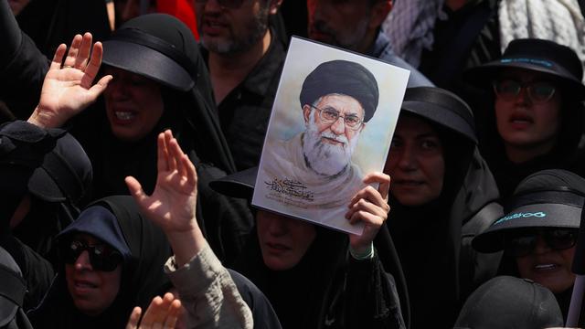 Dunkel gekleidete Menschen bei einem Trauerzug für den getöteten Obersten Führer des Iran, Ajatollah Ali Chamenei. Eine der Person hält ein Bild Chemeneis. 