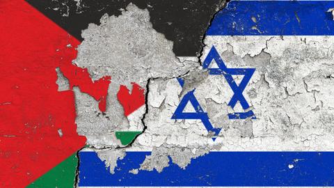 Die Nationalflaggen von Palaestina und Israel auf einer Wand mit aufgeplatzter Farbe und einem schraegen, dicken Riss.