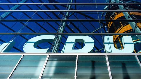 Das weiße CDU-Logo am Konrad-Adenauer-Haus, der CDU-Zentrale, von unten fotografiert.