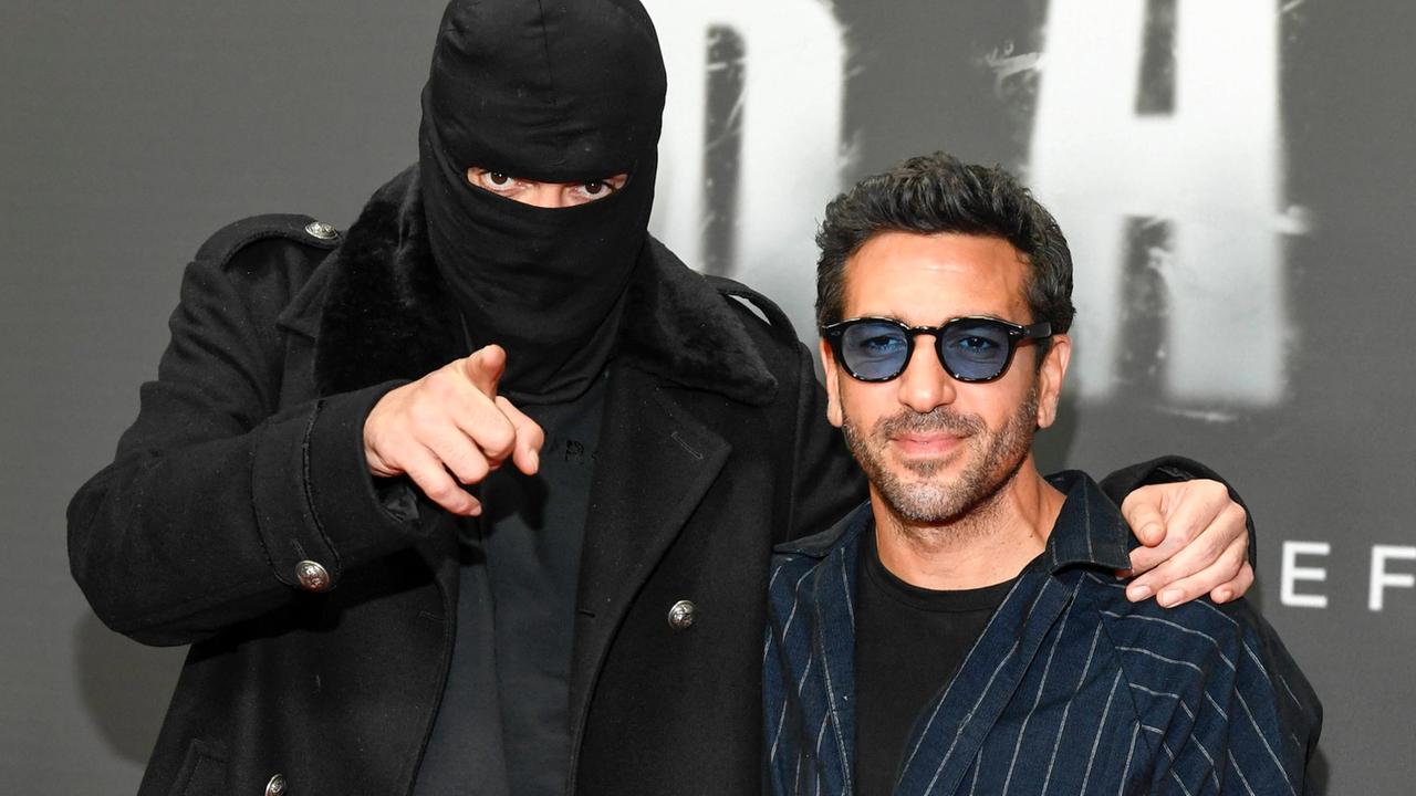 Anhan trägt eine Sturmhaube, zeigt in die Kamera und legt den Arm um Elyas M Barek, der ein dunkelblaue Sonnenbrille trägt. 