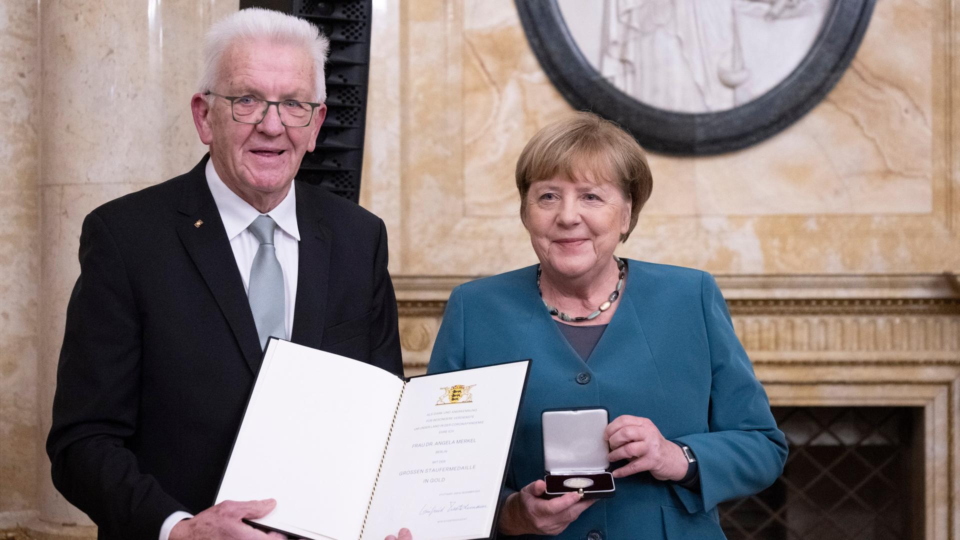 Winfried Kretschmann, Ministerpräsident von Baden-Württemberg, überreicht der ehemaligen Bundeskanzlerin Angela Merkel (CDU) im Neuen Schloss die Staufermedaille in Gold. 