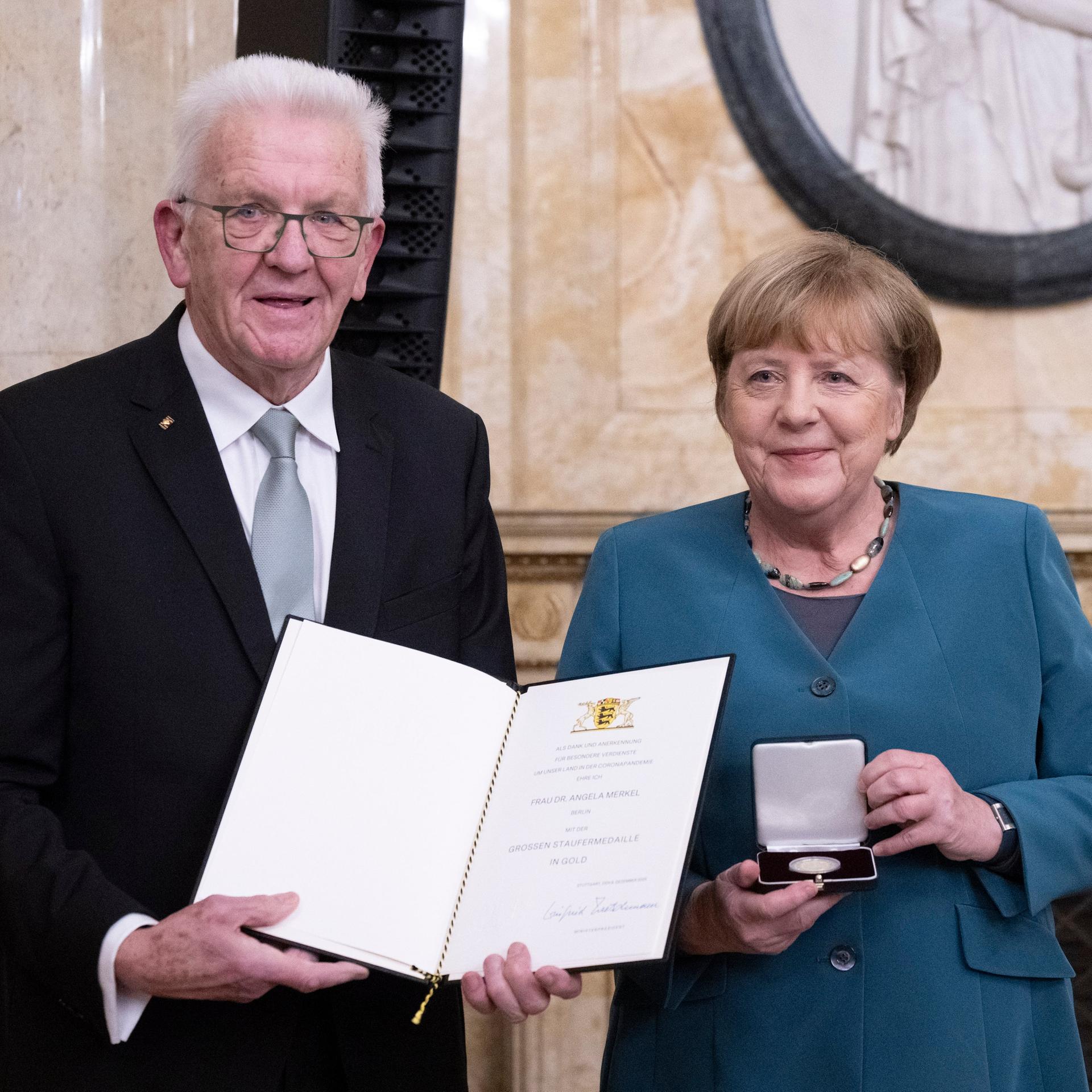 Winfried Kretschmann, Ministerpräsident von Baden-Württemberg, überreicht der ehemaligen Bundeskanzlerin Angela Merkel (CDU) im Neuen Schloss die Staufermedaille in Gold. 