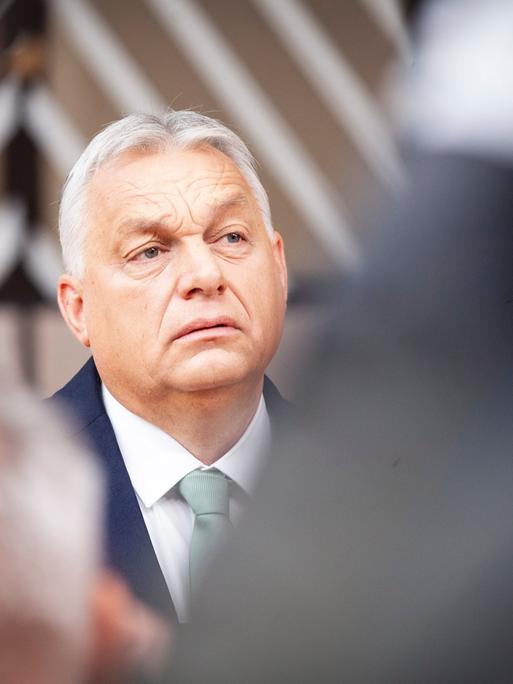 Portrait von Viktor Orban. Er trägt eine dunkle Anzugsjacke und ein weißes Hemd