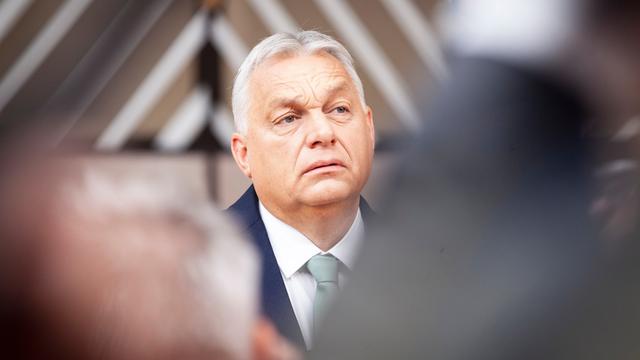 Portrait von Viktor Orban. Er trägt eine dunkle Anzugsjacke und ein weißes Hemd