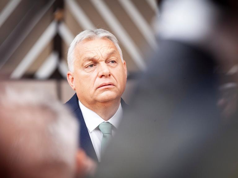 Portrait von Viktor Orban. Er trägt eine dunkle Anzugsjacke und ein weißes Hemd