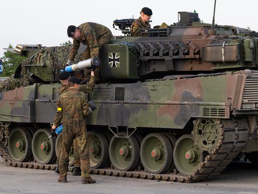 Soldaten der Bundeswehr beladen einen Kampfpanzer mit Übungsmunition.