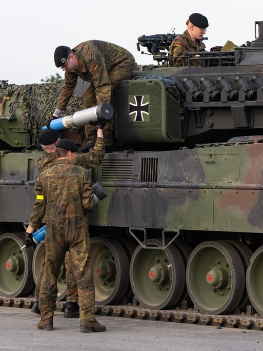 Soldaten der Bundeswehr beladen einen Kampfpanzer mit Übungsmunition.