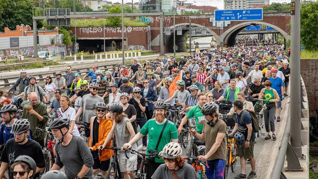 Die Autobahn ist komplett voll mit Menschen und ihren Fahrrädern. Die Räder werden geschoben.
