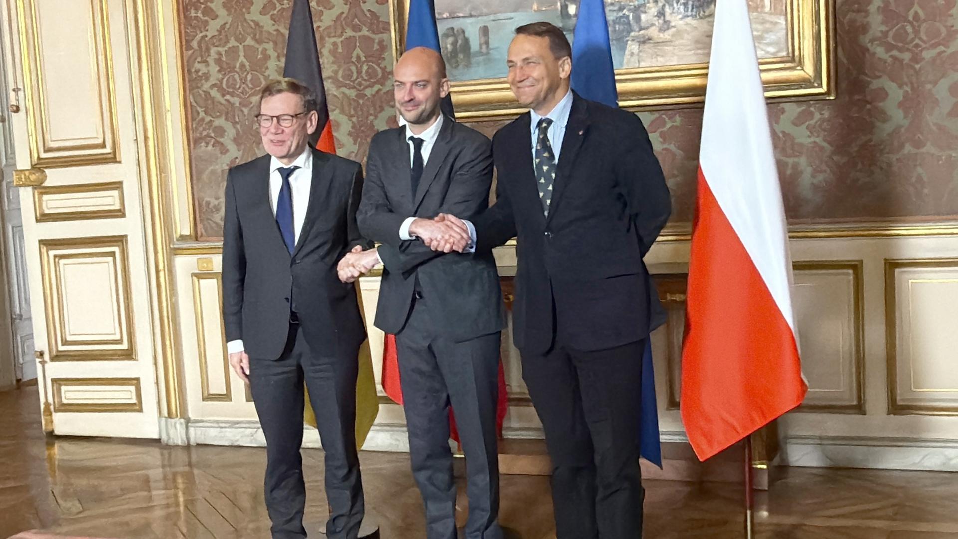 Johann Wadephul (l-r, CDU), Außenminister, als Gastgeber der französische Außenminister Jean-Noel Barrot und sein Amtskollege aus Polen, Radoslaw Sikorski, reichen sich im französischen Außenministerium zum Treffen im Format des Weimarer Dreiecks die Hände. 