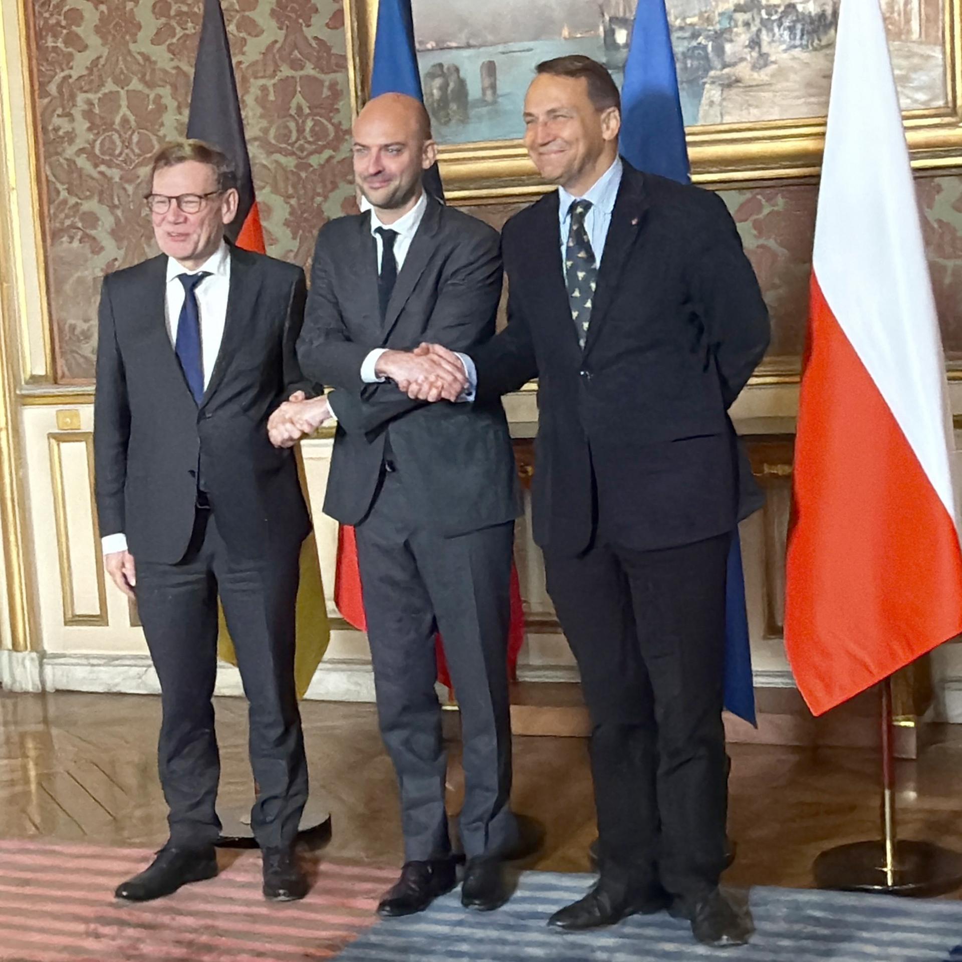 Johann Wadephul (l-r, CDU), Außenminister, als Gastgeber der französische Außenminister Jean-Noel Barrot und sein Amtskollege aus Polen, Radoslaw Sikorski, reichen sich im französischen Außenministerium zum Treffen im Format des Weimarer Dreiecks die Hände. 