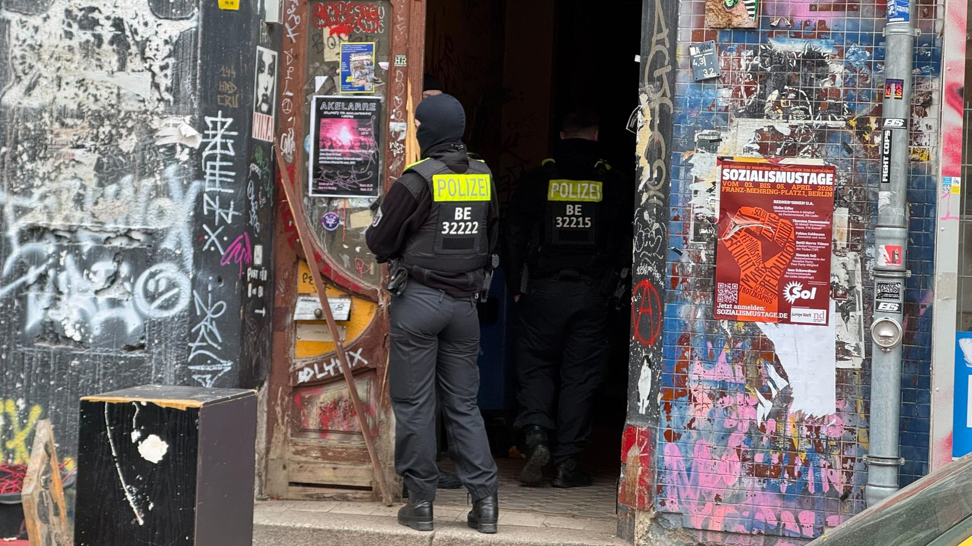 Zwei Polizisten stehen an einem Hauseingang im Berliner Stadtteil Wedding.
