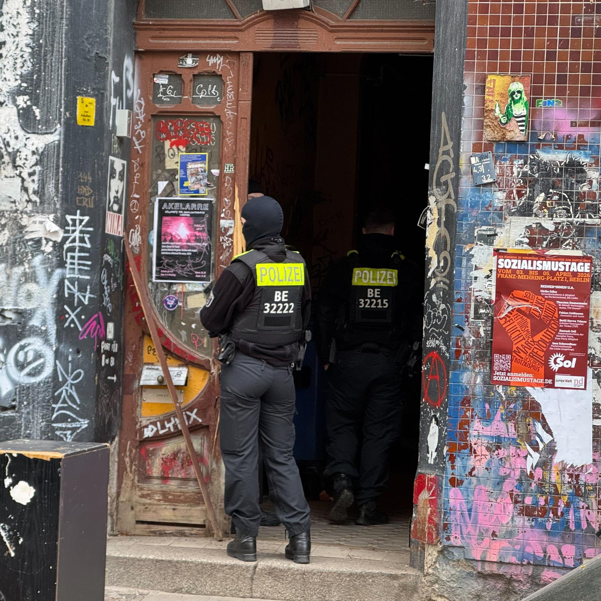 Zwei Polizisten stehen an einem Hauseingang im Berliner Stadtteil Wedding.