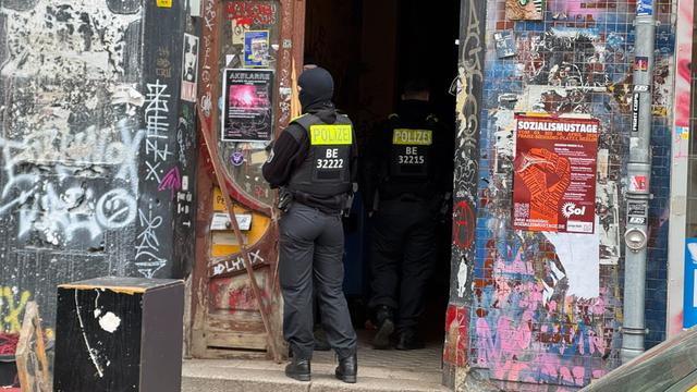 Zwei Polizisten stehen an einem Hauseingang im Berliner Stadtteil Wedding.