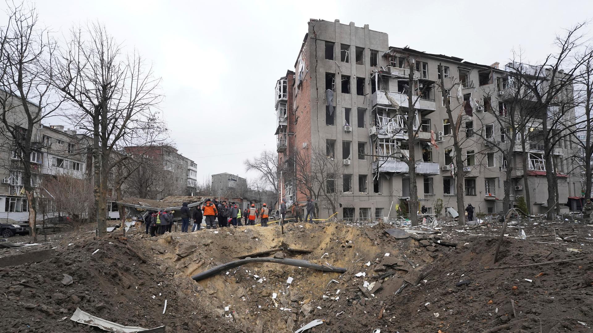 Trümmer vor einem durch einen russischen Raketeneinschlag beschädigten Gebäude