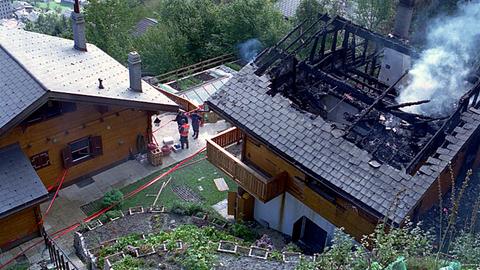 Zwei Chalets in der Schweiz, einer teilweise verbrannt