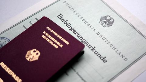 Ein Reisepass liegt auf einer Einbürgerungsurkunde.