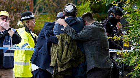 Mitglieder der jüdischen Gemeinde in Manchester trösten sich gegenseitig nach einem Anschlag nahe der Synagoge. 