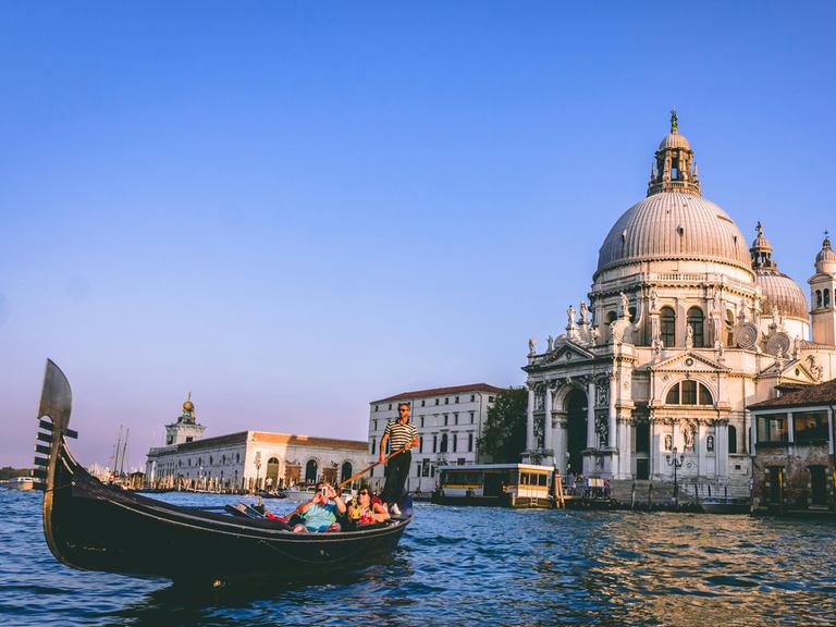 Das Bild zeigt eine Gondel vor einem historischen Gebäude der italienischen Stadt Venedig. 