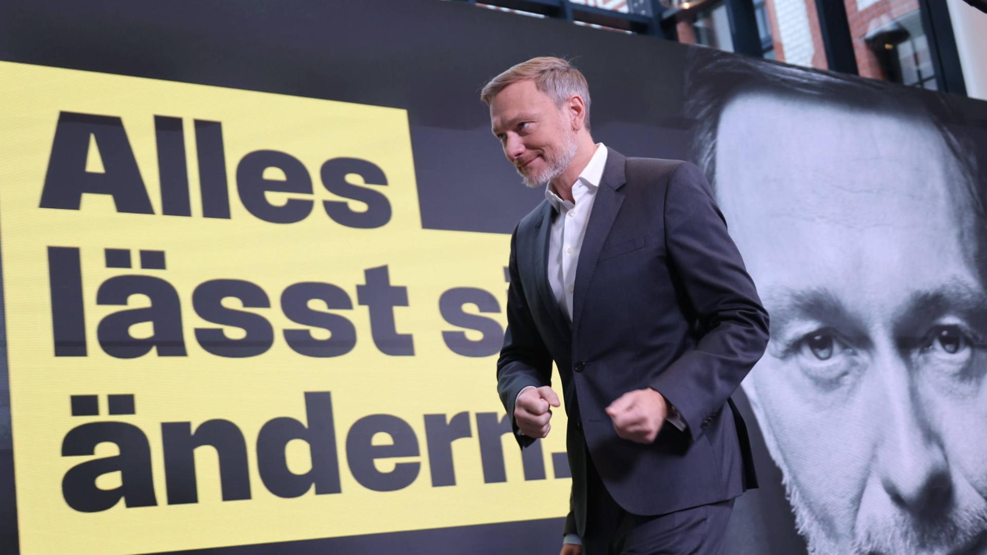 FDP-Chef Christian Lindner läuft an einem Wahlplakat vorbei, auf dem steht "Alles lässt sich ändern."