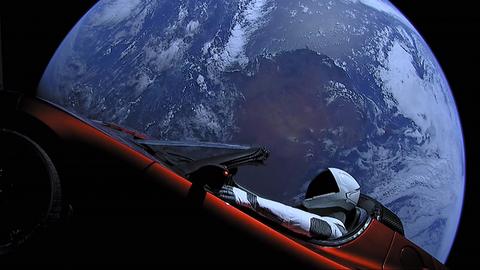 Roter Tesla Roadster im Weltraum mit der Erde im Hintergrund und einem Raumfahrer auf dem Fahrersitz