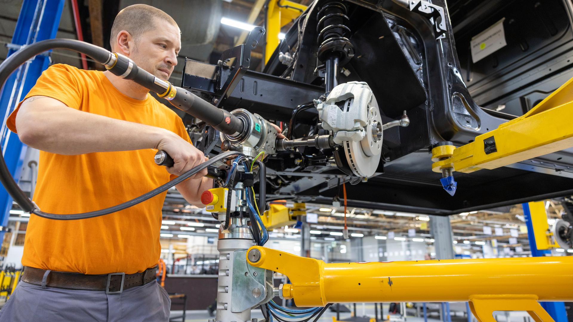 Ein Mitarbeiter montiert Antriebsstränge in der Produktionsstraße von Elektronutzfahrzeugen im Werk der Neapco Europe GmbH (Automobilzulieferer) in Düren.