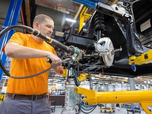 Ein Mitarbeiter montiert Antriebsstränge in der Produktionsstraße von Elektronutzfahrzeugen im Werk der Neapco Europe GmbH (Automobilzulieferer) in Düren.