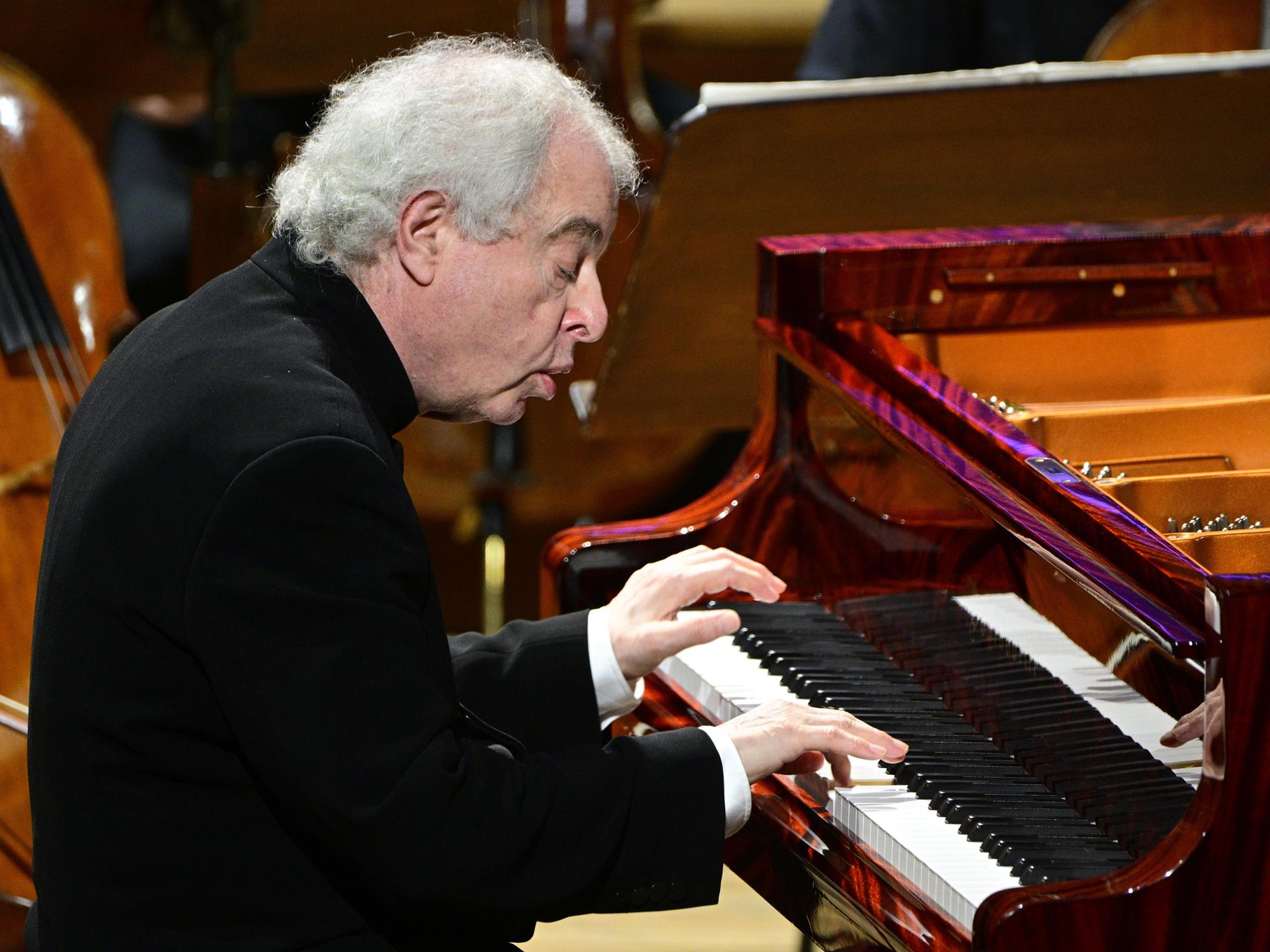 Der Pianist András Schiff sitzt an einem schwarzen Flügel und spielt. Er sitzt leicht nach vorne gebeugt und schaut sehr konzentriert.
Der Pianist András Schiff sitzt an einem schwarzen Flügel und spielt. Er sitzt leicht nach vorne gebeugt und schaut sehr konzentriert.