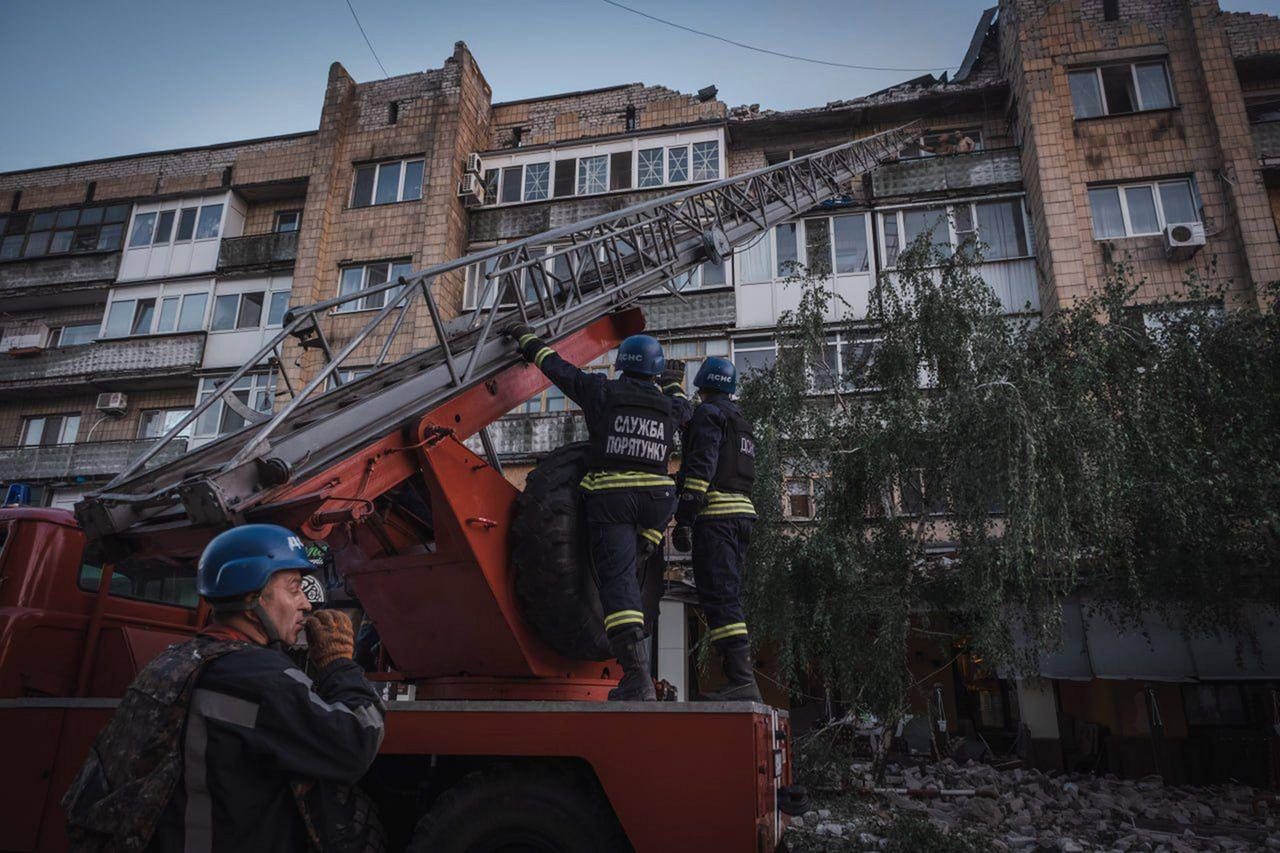 Ukrainische Nothelfer der Feuerwehr im Einsatz vor einem beschädigten Haus. 