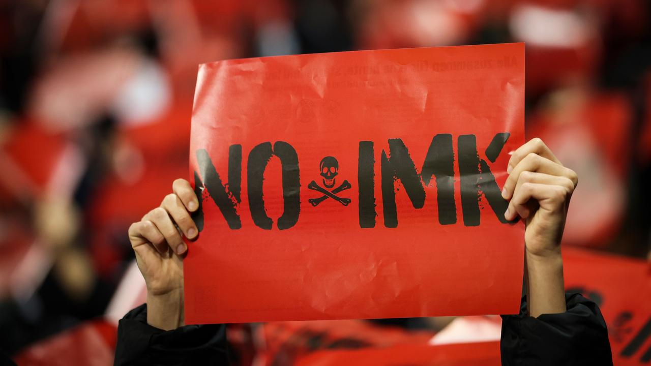 Fans des FC St. Pauli halten Schilder mit dem Text "No IMK" in den ersten Minuten des Spiels.