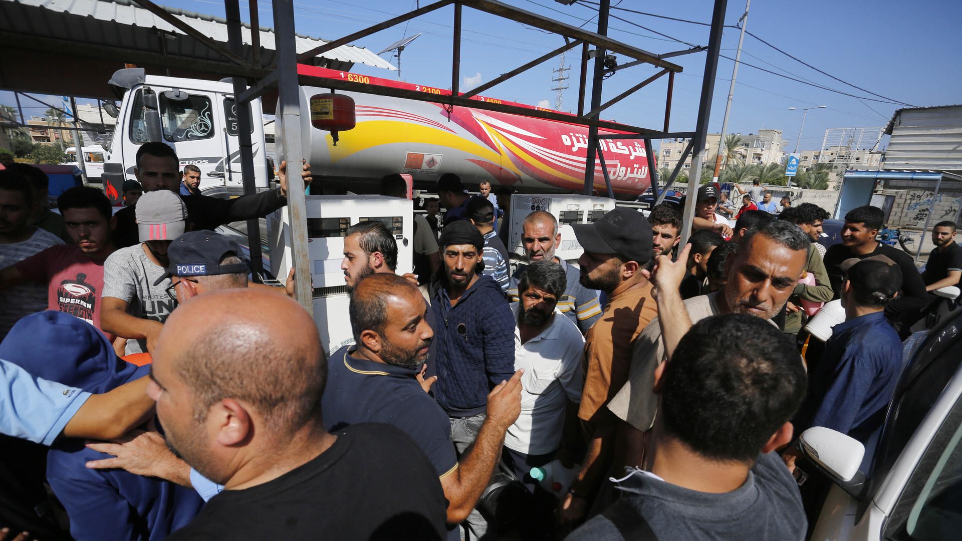 Menschen stehen vor einer Tankstelle in Deir al-Balah, Gaza, um Benzin zu bekommen.